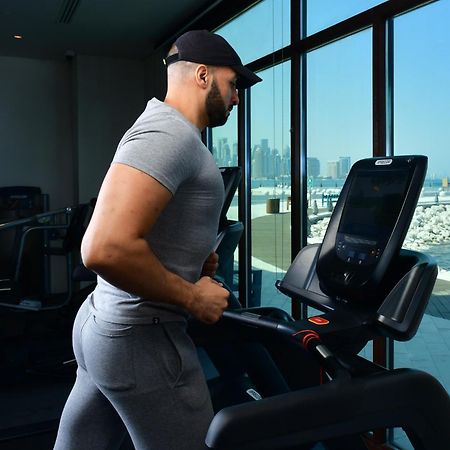 Mina Hotel And Residences By The Torch Доха Экстерьер фото A man exercising on a treadmill